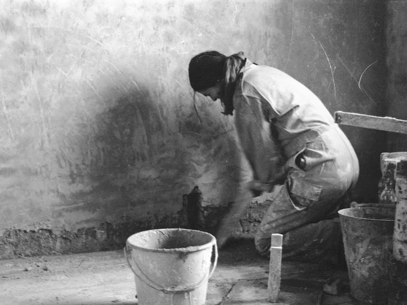 Woman squatter plastering living room